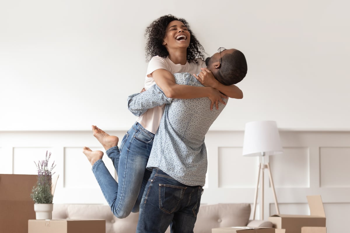 stock-photo-african-husband-lifting-happy-wife-laughing-celebrating-moving-day-with-boxes-excited-first-time-1414418588-1